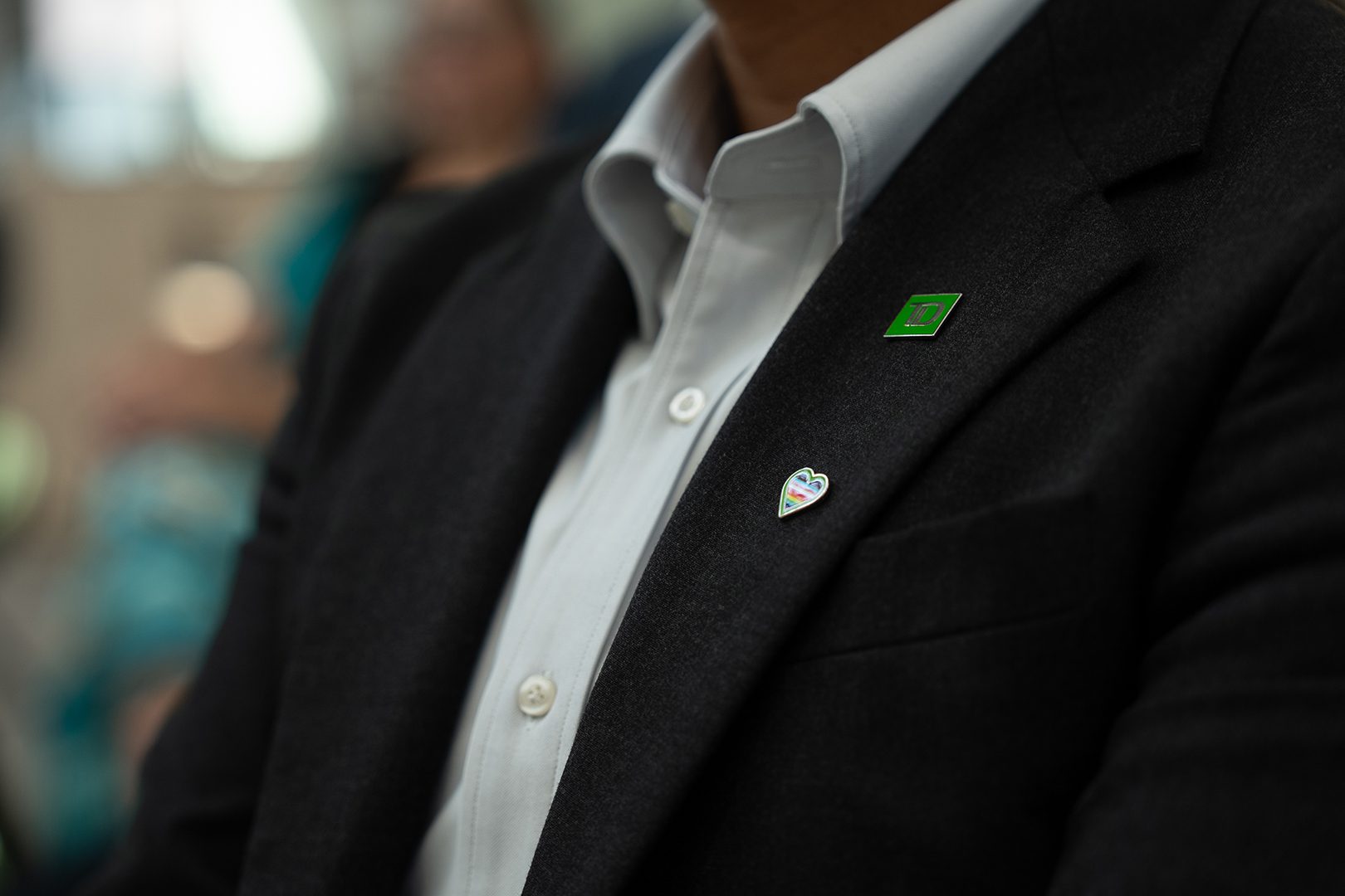 2SLGBTQ+ Une personne avec le toupet teint vert rit à l’extérieur.