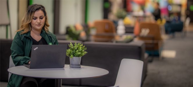 Analyst Un collègue sourit en utilisant une tablette dans un bureau de style loft.