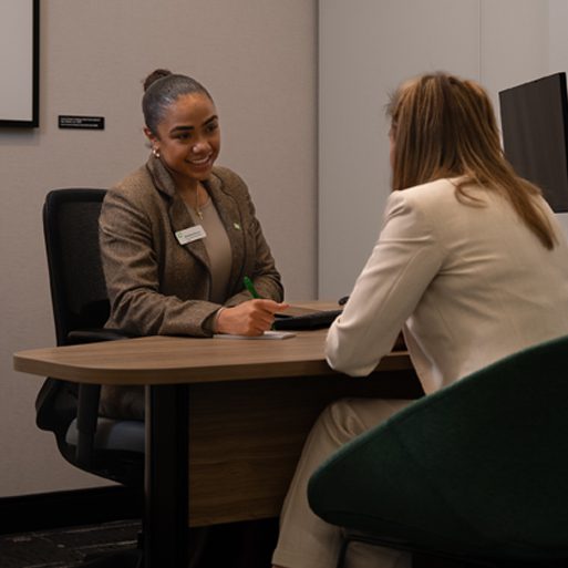 Une collègue en fauteuil roulant dans une succursale de la TD sourit.