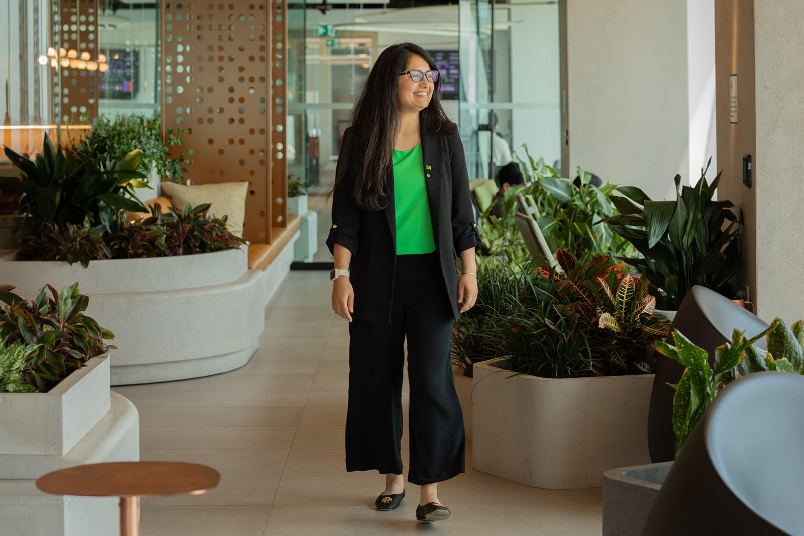 New to Canada Une collègue assise dans un bureau tient son téléphone intelligent.