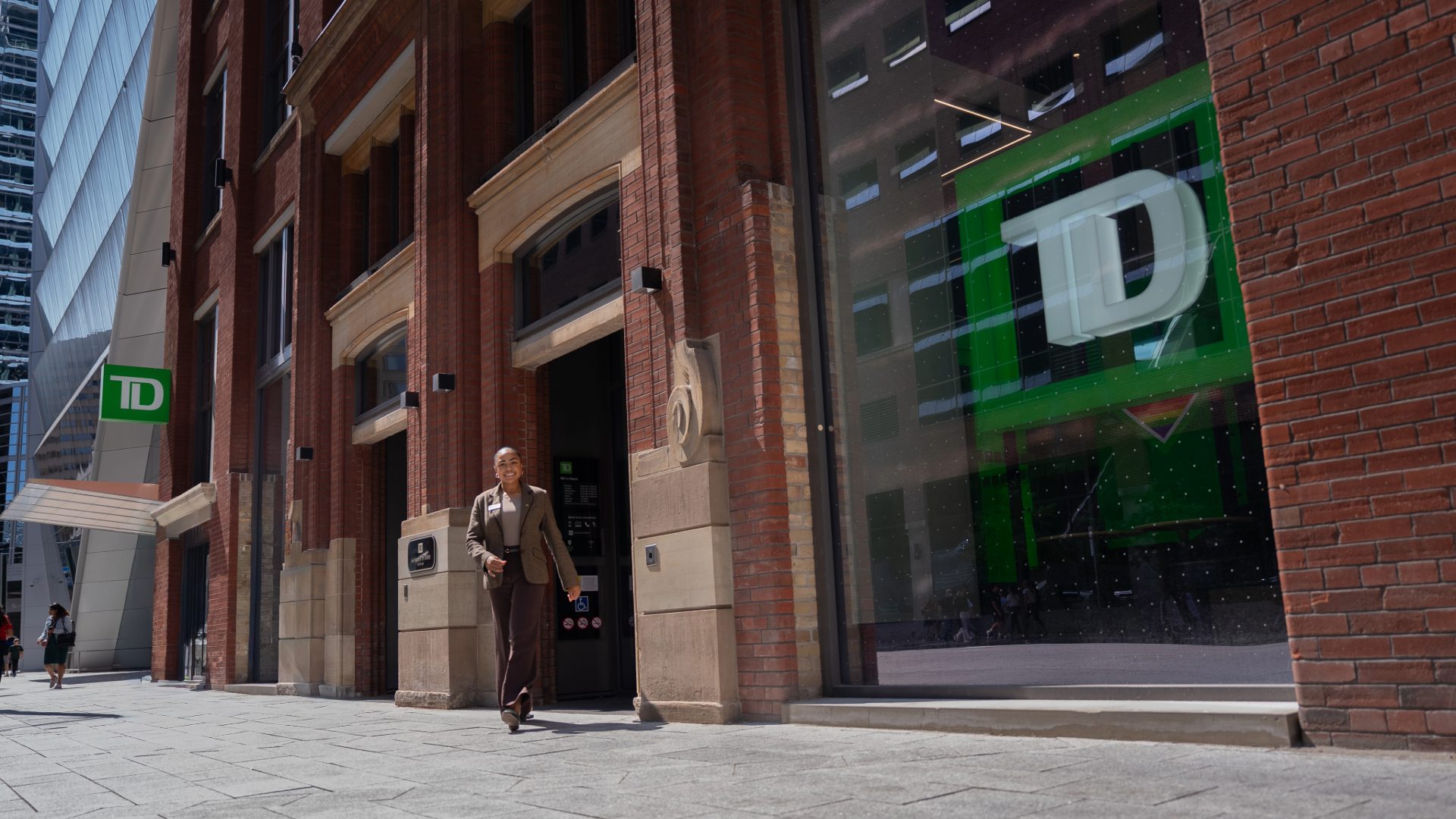 People 3 Une femme sourit à l’extérieur d’une succursale de la TD.