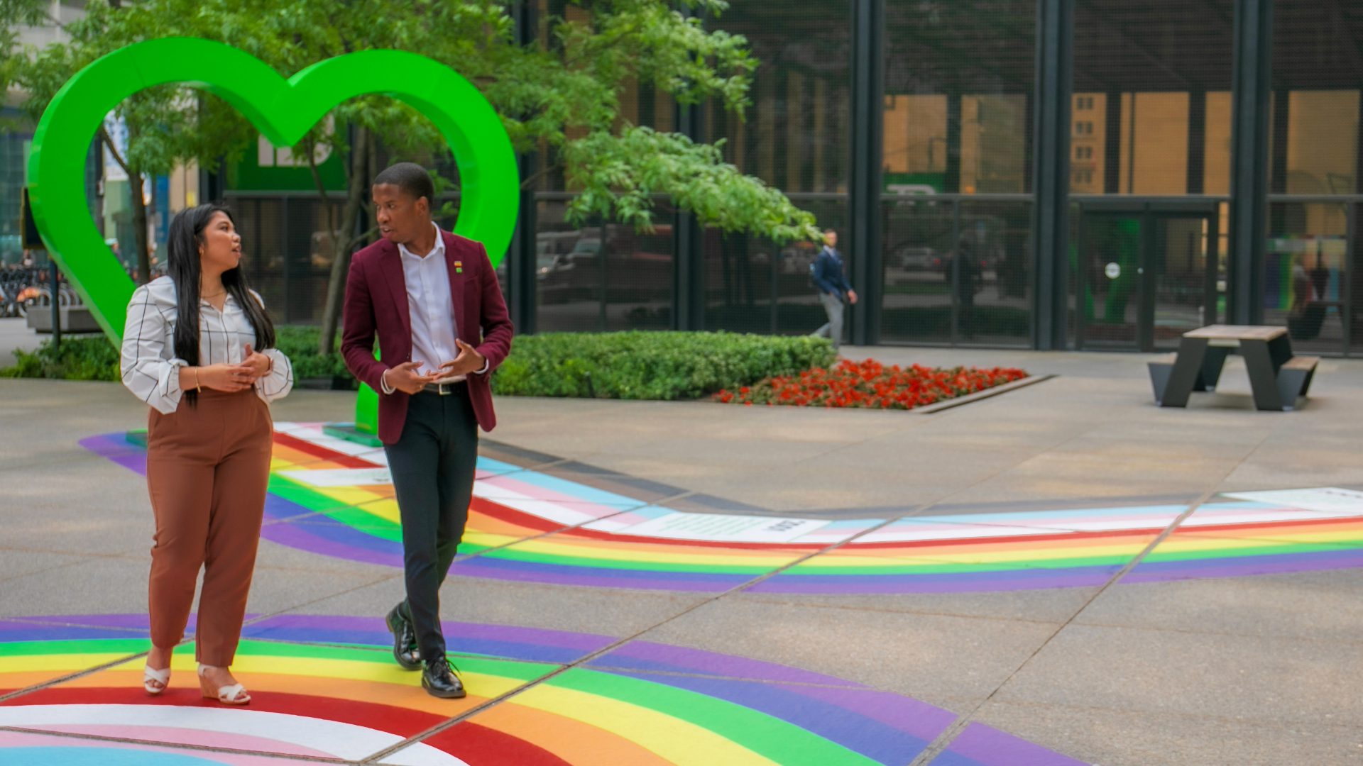 TDProud Two colleagues hold a pride flag featuring a Toronto Blue Jays logo.