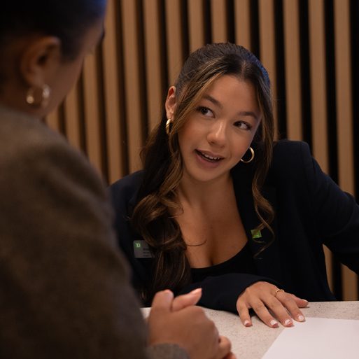 Ts auto A man signs paperwork for a loan at an auto dealership.