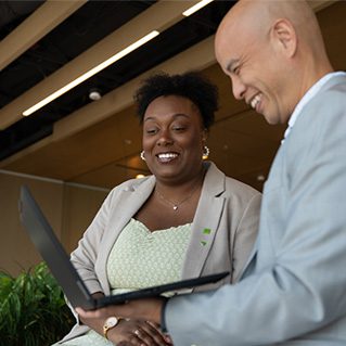 explore job Colleagues have a meeting at a conference table covered in print-outs.
