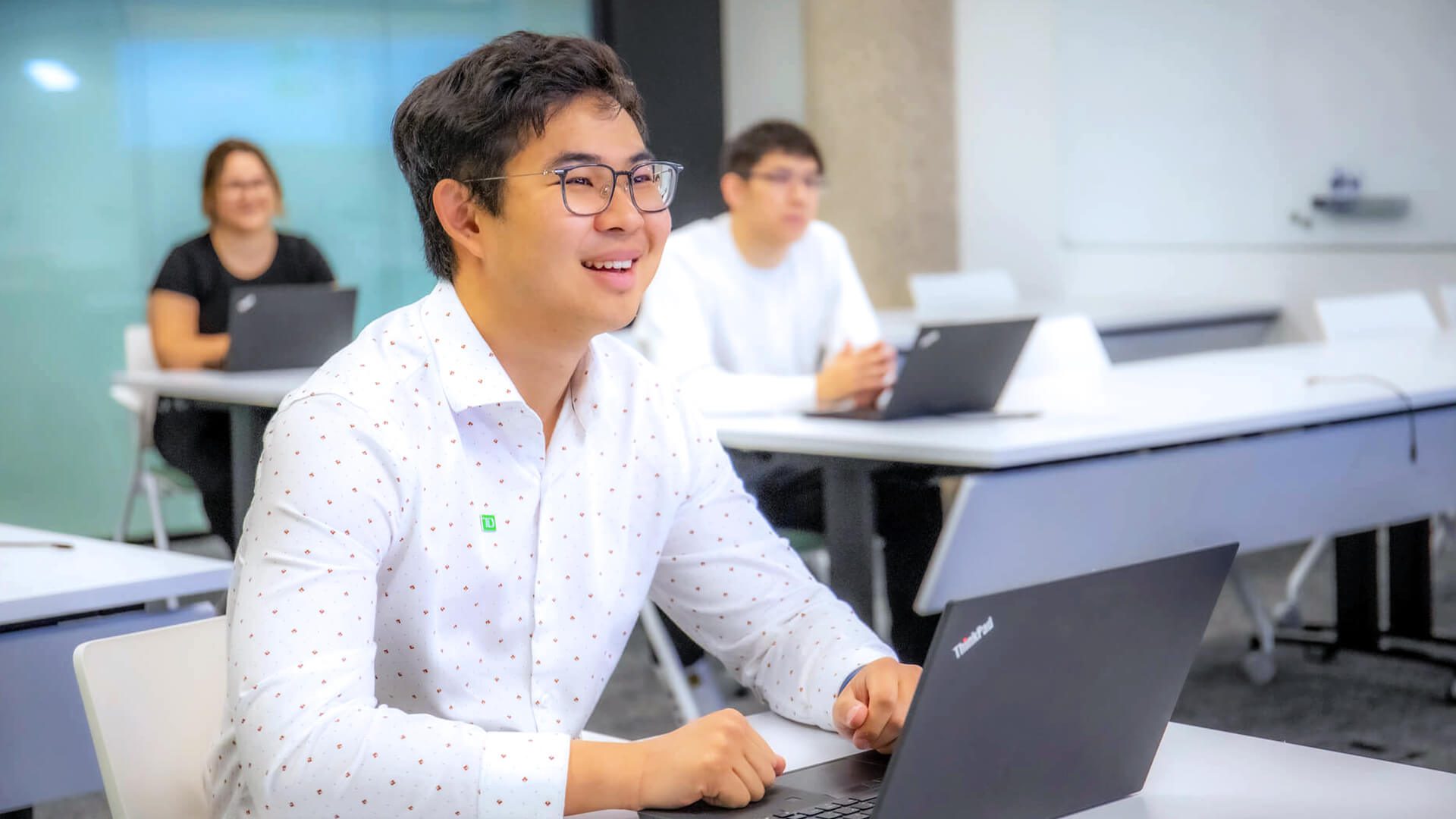 Un groupe de collègues participe à un séminaire de formation dans un bureau de la TD.