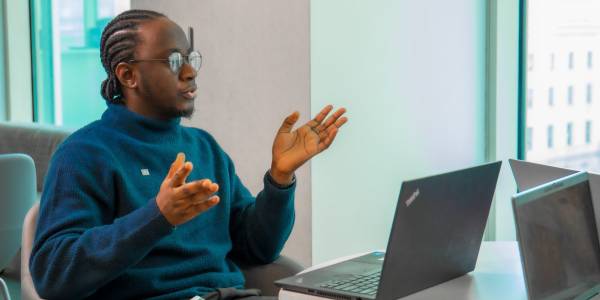A new colleague gestures with their hands in a meeting in a TD office.